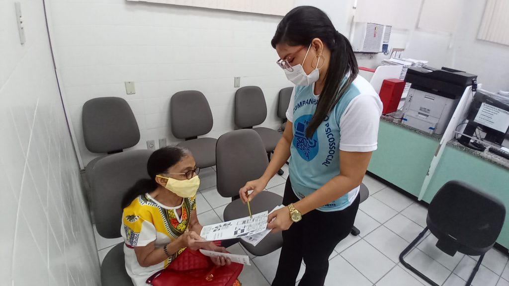 Aposentada recebe orientações de assistente social sobre serviços do IPMB.